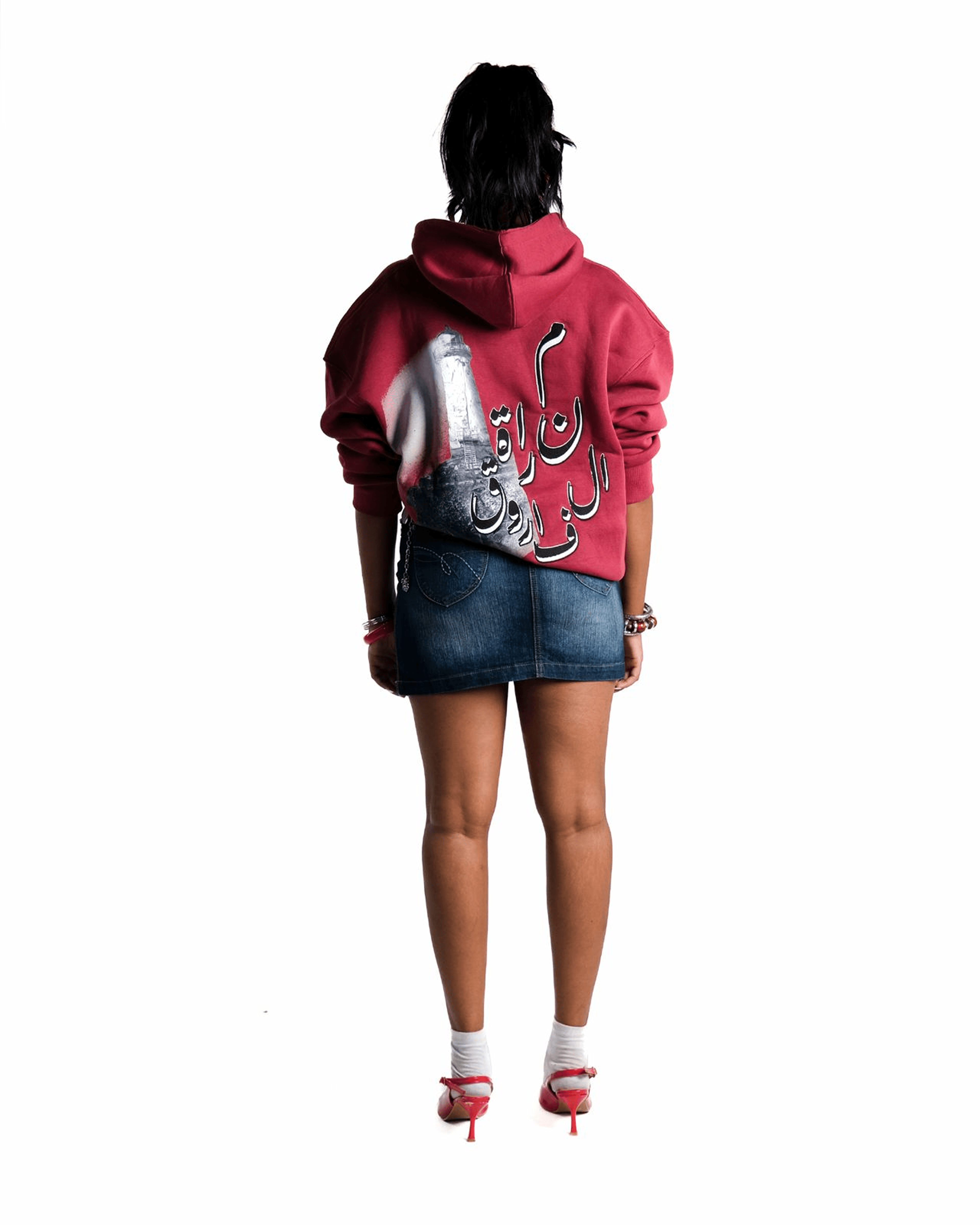 Back of a maroon hoodie with lighthouse print and Arabic calligraphy