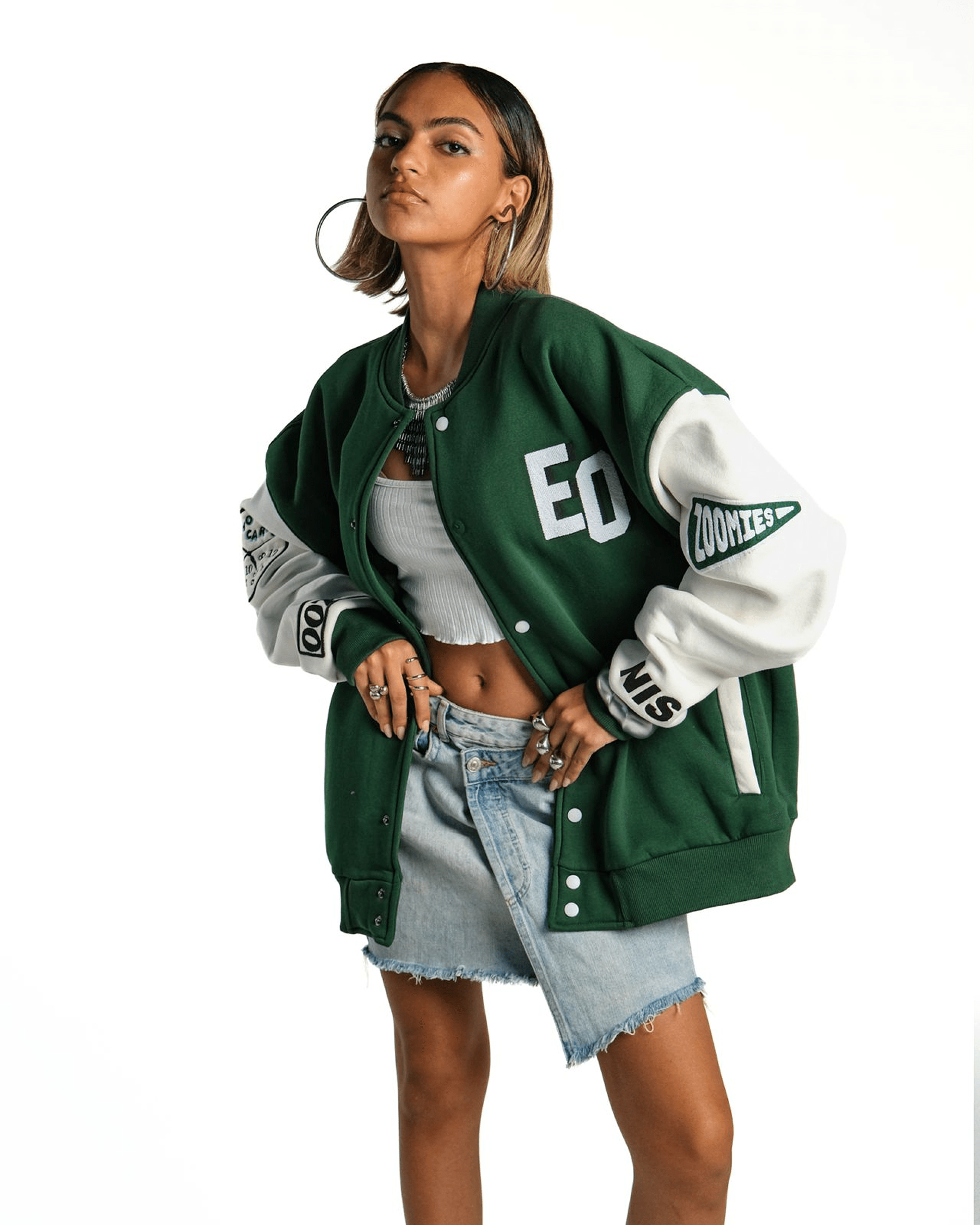 Model in a green Zoomies varsity jacket and denim skirt